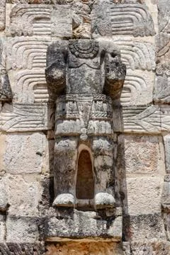Large Mayan statue, with missing head, set into a wall. Stock Photos