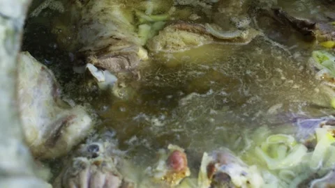 Large meat chunks boiling in broth in huge ancient cauldron for pilaf Stock Footage 332143571