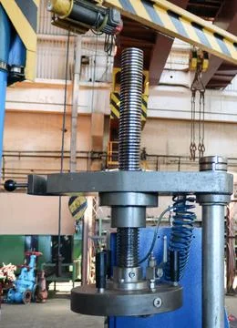 A large metal automatic press with a thread and an electric motor in the prod Stock Photos