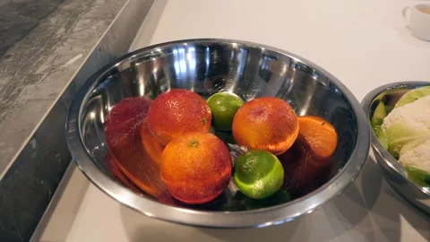 A large metal bowl filled with oranges and limes. Video stock 151381353