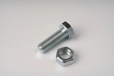 A large metal threaded bolt and a nut for it side by side Stock Photos