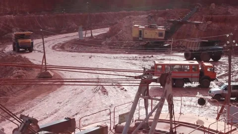 A large mining dump truck enters the quarry, a nearby huge mining excavator Stock Footage 122217420