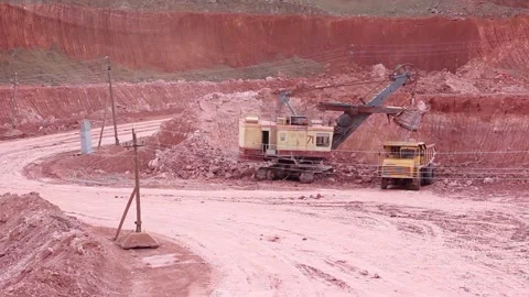 A large mining dump truck enters the quarry, a nearby huge mining excavator Stock Footage 122217567