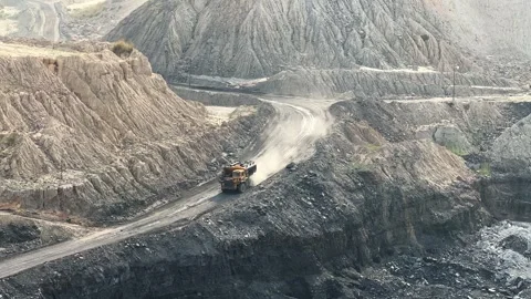 Large mining dump trucks, also known as haul truck going into the coal mine in Vidéo 313352640