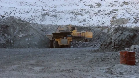 A large mining excavator loads a huge mining truck with stones and sand. Stock Footage 124192706