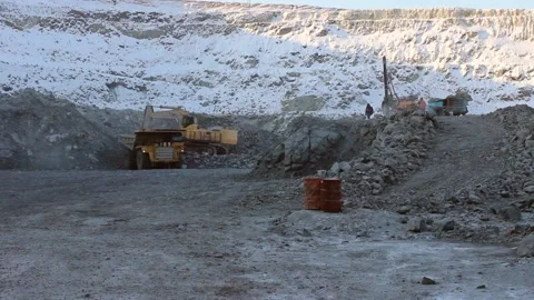 A large mining excavator loads a huge mining truck with stones and sand. Stock Footage 124192732
