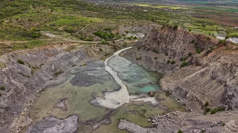 Large mining pit with water and greenery in the background Stock Footage 338275705