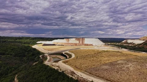 Large mining site with dirt and water under cloudy sky in Texas Stock Footage 339649948