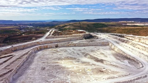 Large mining site in a mountainous area with heavy machinery and exposed earth Stock Footage 345455422