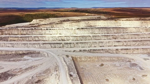 Large mining site shows layers of earth and machinery at work during daylight Stock Footage 345455425