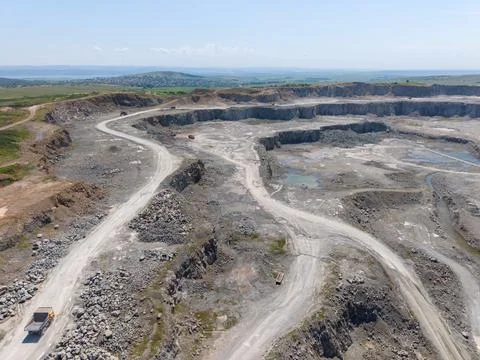 Large mining site with winding roads and machinery under clear sky Stock-Fotos