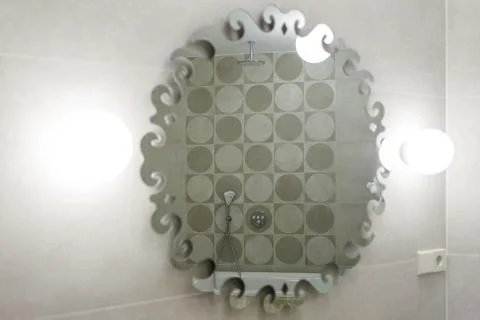 Large mirror with backlight. It reflects marble wall, rain shower and shower  Stock Photos