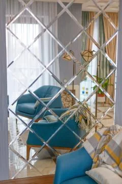 A large mirror on the wall with a reflection of the living room with it. Stock Photos