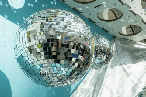 Large mirrored sphere hangs in bright interior space and throws scattered ref Stock Photos