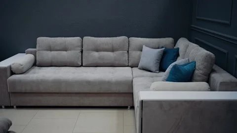 Large, modern, beige sofa with ten beige and blue decorative pillows, next to a Stock Footage 235059597