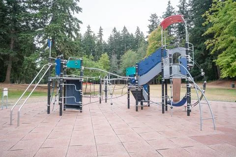 A large modern playground climbing structure with ropes and slides, surrounde Stock Photos