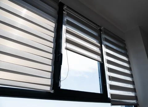 Large modern windows with zebra blinds partially open Foto stock
