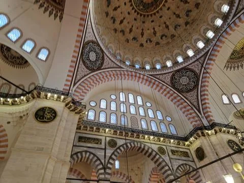 Large mosque interior with ornate dome and arched windows Stock Photos
