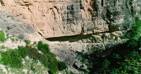 Large mountain stone wall and wall hung trail and hiker under the stone Stock Footage 146964787