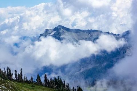 Large mountains covered in dense cloud and fog Stock Photos