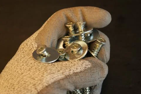 Large mounting screws in the hand of the assembler. Close-up. Stock Photos