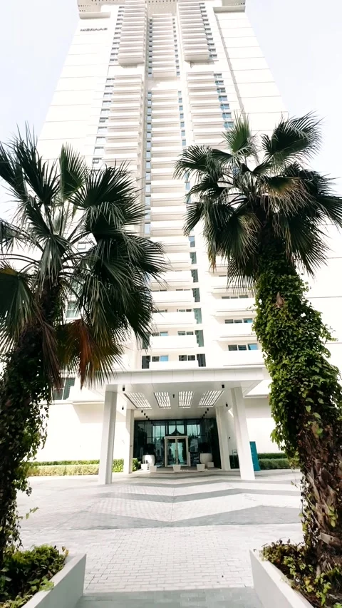 A large multi-storey house surrounded by palm trees near the ocean Stock Footage 263010930