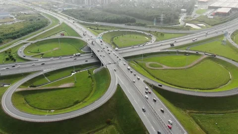 Large multilevel autobahn traffic intersection among meadows Stock Footage 164254107