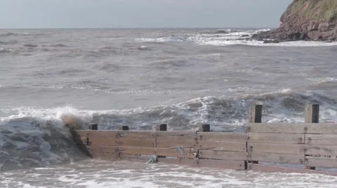 Large Murky Brown Waves Breaking over Sea Defences in Stormy Weather Stock Footage 56349927
