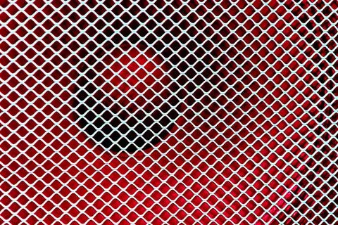 Large music loudspeaker covered with a metal protective mesh on red Stock Photos