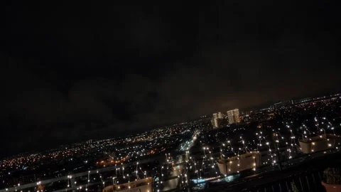 Large night city with lights from a high roof of a multi-story skyscraper Stock Footage 312077628