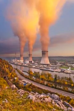 A large nuclear power station by a river during sunset Stock Photos