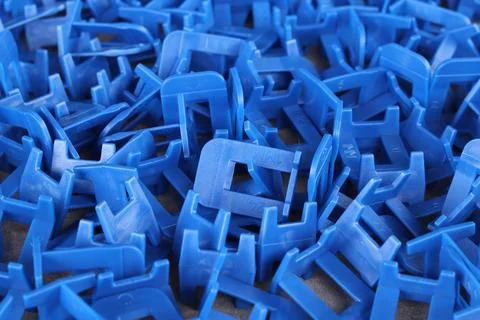 A large number of blue plastic elements of the tile leveling system Foto stock
