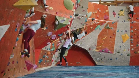 A large number of children train on the wall of the climbing wall indoors Stock Footage 275811586