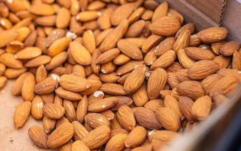 A large number of closely packed almonds with a light brown hue and textured  Stock Photos