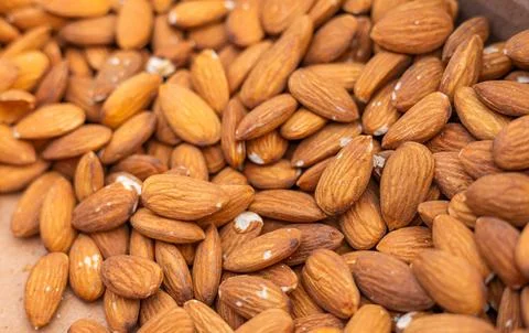 A large number of closely packed almonds with a light brown hue and textured  Stock Photos