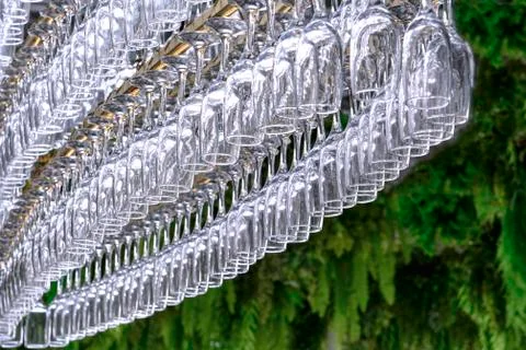 A large number of glasses in the form of an oval hang on the holder at the ba Stock Photos