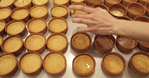 A large number of mini-tarts are laid out in even rows Stock Footage 253409520
