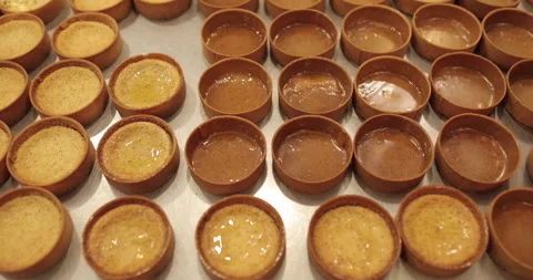 A large number of mini-tarts are laid out in even rows Stock Footage 253409942