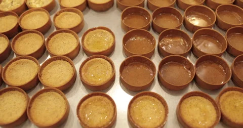 A large number of mini-tarts are laid out in even rows Stock Footage 253409943