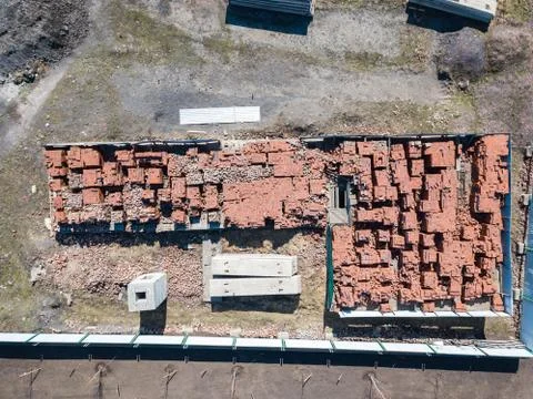 A large number of red bricks stacked on pallets near the construction site in Stock Photos