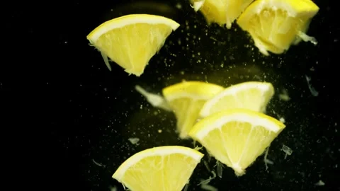 A large number of small pieces of lemon fall into the water. Stock Footage 263244652