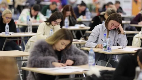 Large number of students sustaining a written exam indoors Видео 257564574