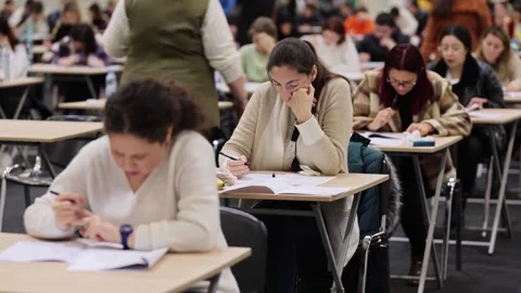Large number of students sustaining a written exam indoors Видео 257564578