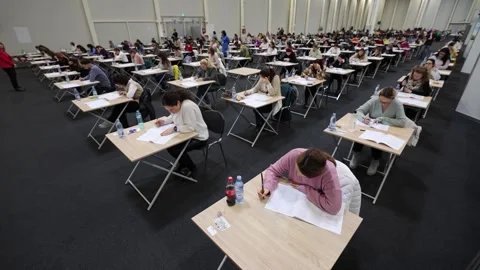 Large number of students sustaining a written exam indoors Видео 257564582