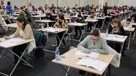 Large number of students sustaining a written exam indoors Видео 257564602