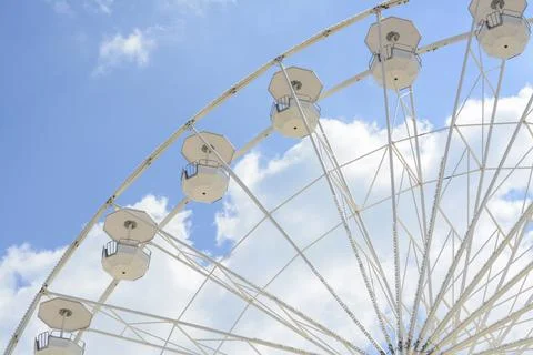 Large observation wheel against blue cloudy sky, low angle view Stock Photos