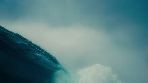 Large ocean wave curling breaking with sparkling spray deep blue water Stockbeeldmateriaal 333446323