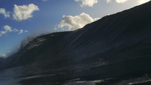 Large Ocean Wave Rising Beneath Bright Clouds in Ultra Slow Motion Stock Footage 344382451