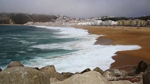 Large ocean waves on Atlantic cost beach in Nazare, Portugal during misty day Stock Footage 67805305