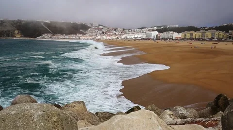Large ocean waves on Atlantic cost beach during misty day in Nazare, Portugal Stock Footage 67805430